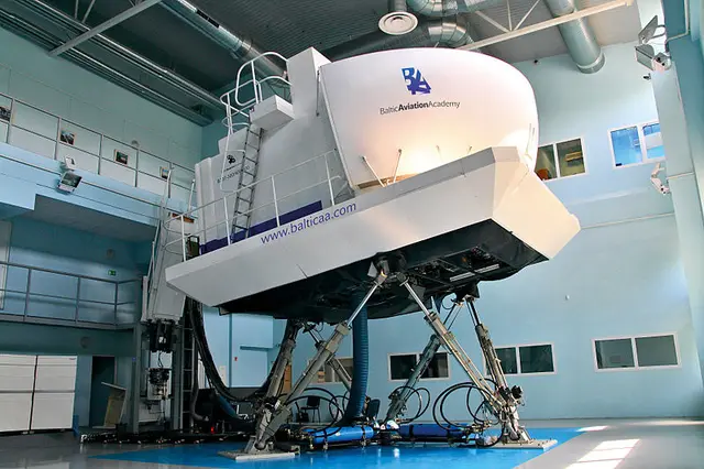 A full-motion Boeing 737 flight simulator raised on hydraulic legs inside a training hangar at Baltic Aviation Academy.
