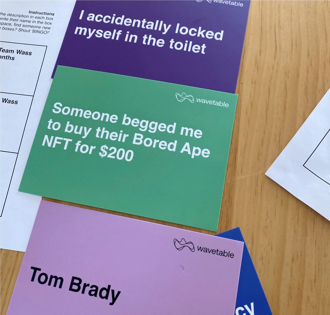 Wavetable game cards on a table with icebreaker prompts such as locking yourself in the toilet, plus a name card