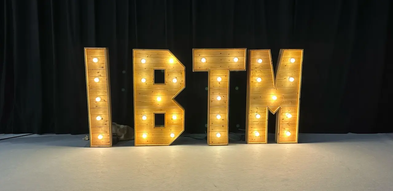 The lit IBTM sign on the show floor in Barcelona